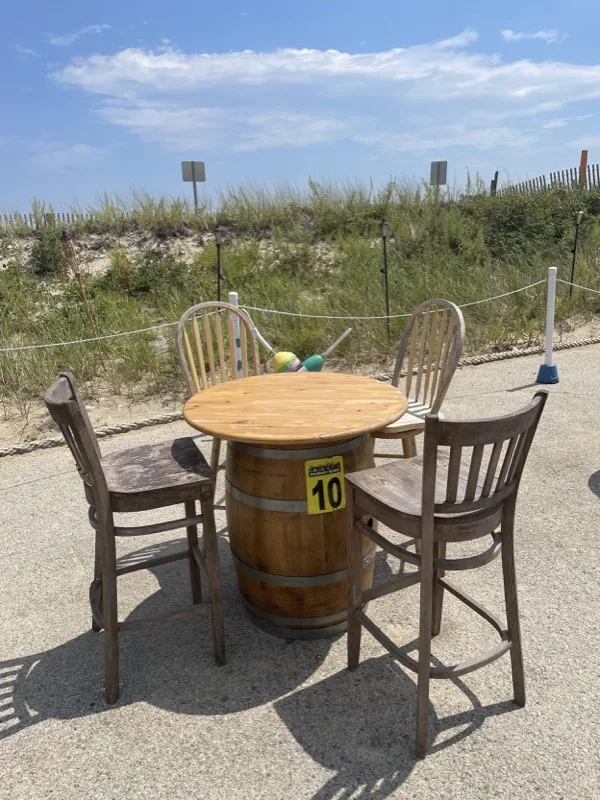 Outdoor barrel-table seating with beach dunes at Blakeman's